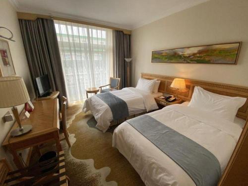 a hotel room with two beds and a window at Beijing Friendship Hotel Jing Bin Building in Beijing