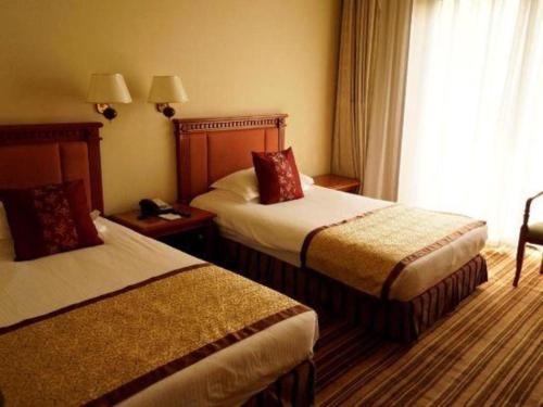 a hotel room with two beds and a window at Beijing Friendship Hotel Jing Bin Building in Beijing