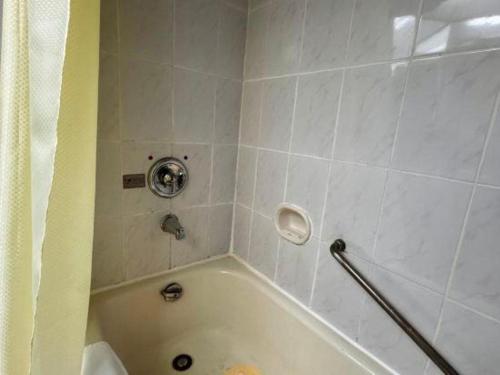 a bathroom with a white tub with a shower at Beijing Friendship Hotel Jing Bin Building in Beijing