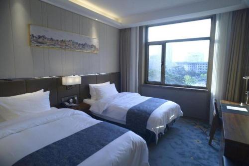 a hotel room with two beds and a window at Beijing Friendship Hotel Jing Bin Building in Beijing