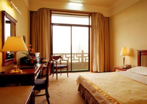 a hotel room with a bed and a large window at Beijing Friendship Hotel Jing Bin Building in Beijing
