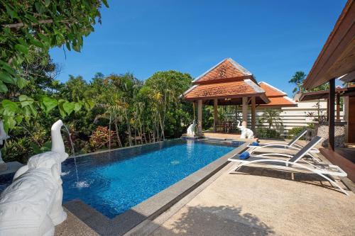 a swimming pool with chairs and a gazebo at Tropical Living at 3BR Pool Villa Bianca, Baan Bua Luxury Estate, Nai Harn Beach in Rawai Beach