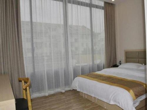 a bedroom with a bed and a large window at Shell Shanghai Jiading Nanxiang Town Minzhu Street Hotel in Shanghai