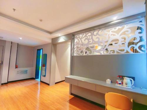 a room with a desk and a wall at 7 Days Inn Yining Xintiandi in Kipekyüzi