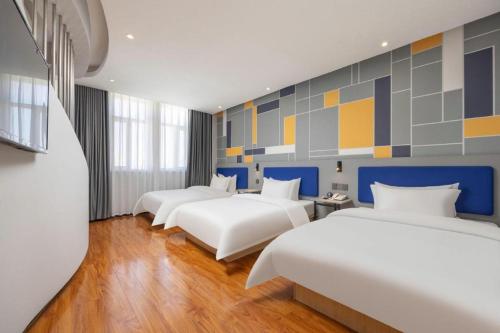 a row of beds in a room at 7 Days Inn Yining Xintiandi in Kipekyüzi