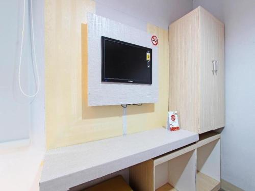 a living room with a tv on a wall at OYO 91531 Dreamstay 2 in Semarang