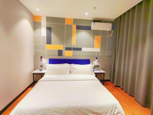 a bedroom with a large white bed with two tables at 7 Days Inn Yining Xintiandi in Kipekyüzi