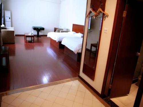 a hotel room with two beds and a mirror at GreenTree Inn Rizhao Yantai Road in Rizhao