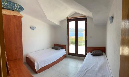 Un dormitorio con dos camas y una ventana. en Appartment with a view in Necujam, en Nečujam