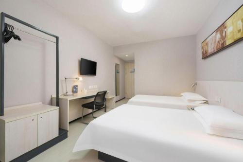 a white room with two beds and a desk at Jinjiang Inn Dalian Development Zone Jinma Road Light Railway Station in Jinzhou