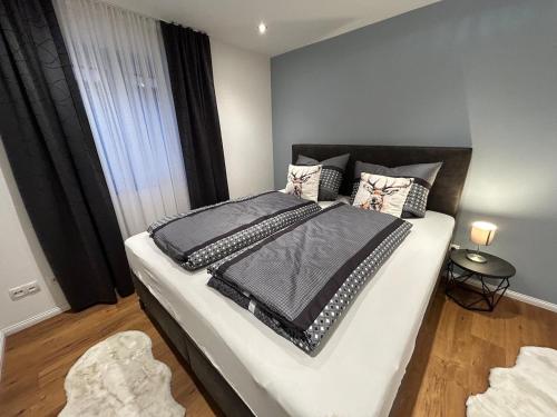 a bedroom with a large bed with black and white pillows at BERGSEERUHE - FeWo Höfats in Nesselwang