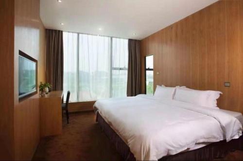 a bedroom with a large bed and a large window at The Art Hotel in Shenzhen