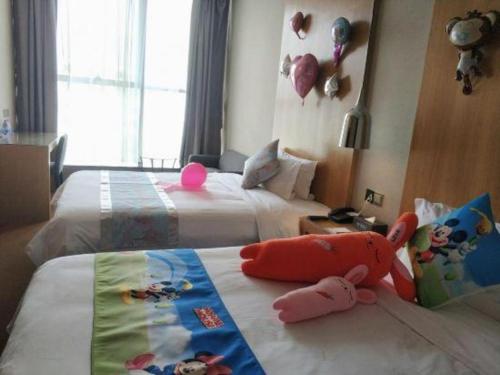 a bedroom with two beds with stuffed animals on the bed at The Art Hotel in Shenzhen