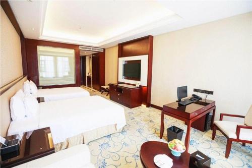 a hotel room with two beds and a desk at Linyi Blue Horizon International Hotel Yi He in Linyi