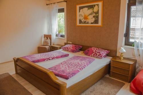 - une chambre avec un lit avec des draps roses et une fenêtre dans l'établissement Zimmer zur ehemaligen Weinstube, à Untermberg