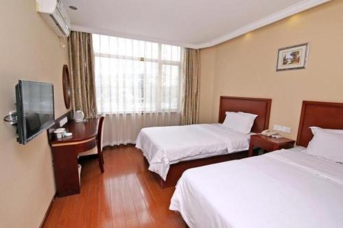 a hotel room with two beds and a television at GreenTree Inn Shanghai Hongqiao Airport Huqingping Highway Shell Hotel in Shanghai
