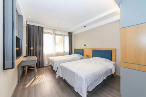 a hotel room with two beds and a desk at GreenTree Alliance Jiangsu Yangzhou middle Wenchang Road Municipal Government Hotel in Yangzhou