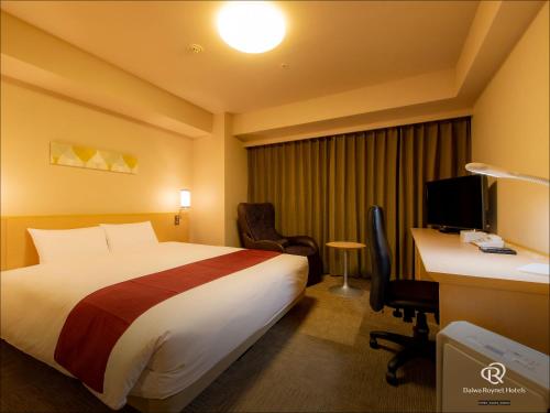 a hotel room with a bed and a desk and a computer at Daiwa Roynet Hotel Hakata-Gion in Fukuoka