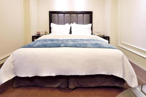 a large bed with a blue and white comforter at Jinjiang Metropolo Hotel Classiq YMCA People Square in Shanghai