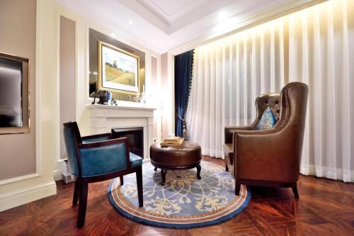 a living room with two chairs and a fireplace at Jinjiang Metropolo Hotel Classiq YMCA People Square in Shanghai