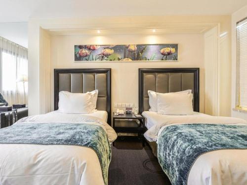 a hotel room with two beds with white sheets at Jinjiang Metropolo Hotel Classiq YMCA People Square in Shanghai