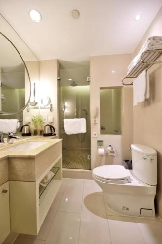 a bathroom with a toilet and a sink and a shower at Jinjiang Metropolo Hotel Classiq YMCA People Square in Shanghai
