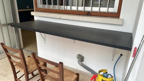 a black counter on a wall next to a chair at Unique City Hostel 100 meters from Beach in Larnaka