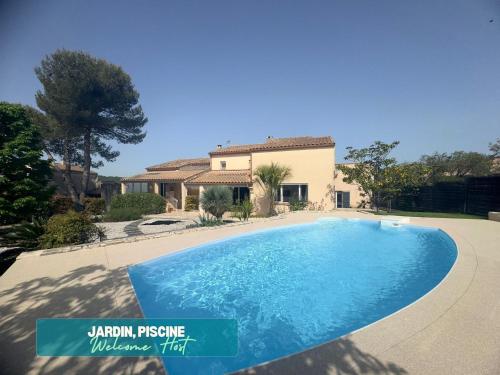 une grande piscine bleue devant une maison dans l'établissement La spacieuse villa, piscine et grands espaces, à Teyran