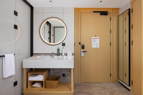 a bathroom with a sink and a mirror at Hilton Garden Inn Huai'An Huaiyin in Huai'an