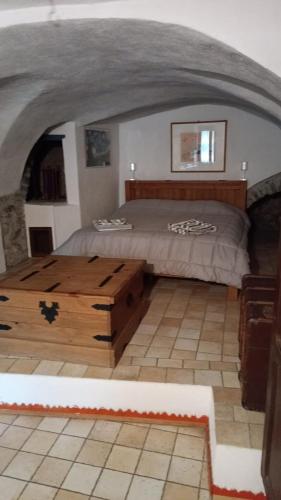 a bedroom with a bed and a wooden coffee table at La casa di Ele in Apricale