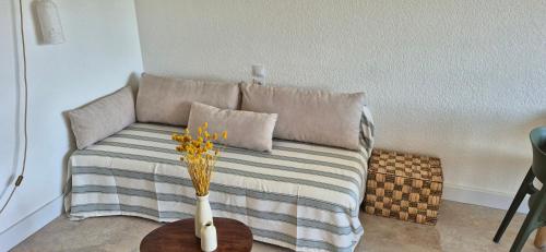 - un canapé dans le salon avec un vase sur une table dans l'établissement Panoramic, Superbe vue lagon pour ce joli studio rénové, au Cap d'Agde