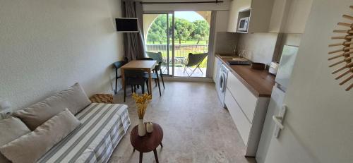 un petit salon avec un canapé et une cuisine dans l'établissement Panoramic, Superbe vue lagon pour ce joli studio rénové, au Cap d'Agde