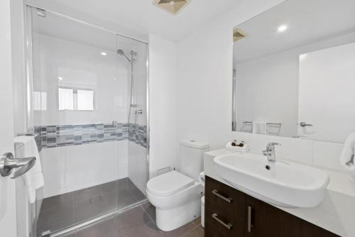 a bathroom with a sink and a toilet and a shower at Pacific Sands Apartments Mackay in Mackay
