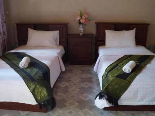 two beds sitting next to each other in a room at Phetphaylin Hotel in Pakse