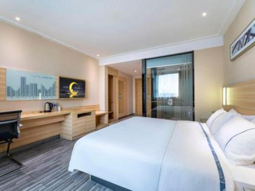 a large bedroom with a large white bed and a desk at City Comfort Inn Foshan Shunde Daliang Qinghui Garden Xinsong in Shunde