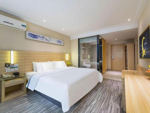 a large white bed in a hotel room at City Comfort Inn Foshan Shunde Daliang Qinghui Garden Xinsong in Shunde