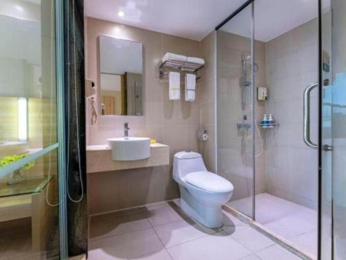 a bathroom with a toilet and a sink and a shower at City Comfort Inn Foshan Shunde Daliang Qinghui Garden Xinsong in Shunde