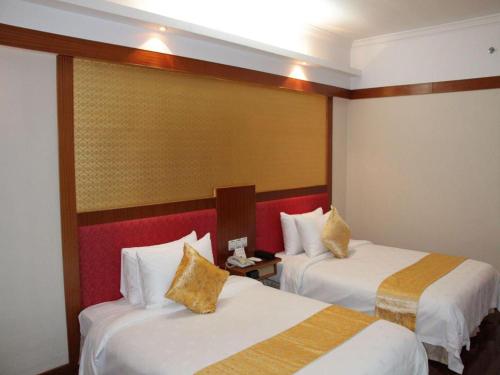 a hotel room with two beds in a room at Golden Lustre Hotel in Shenzhen