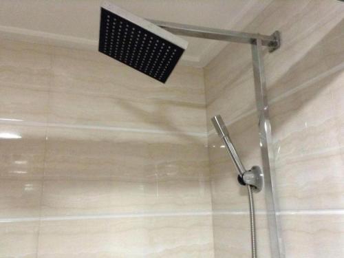 a shower with a shower head in a bathroom at Golden Lustre Hotel in Shenzhen