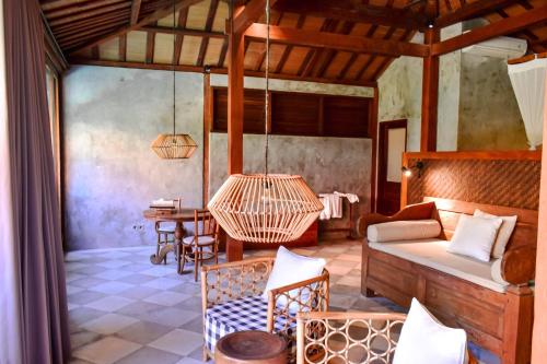 a bedroom with a bed and a table and chairs at ZIN Berawa Villas & Bungalows in Canggu