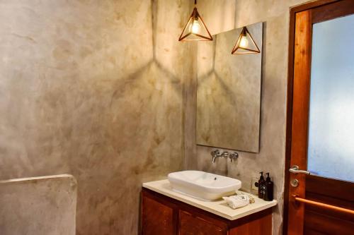 a bathroom with a sink and a mirror at ZIN Berawa Villas & Bungalows in Canggu