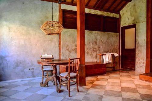 a dining room with a wooden table and chairs at ZIN Berawa Villas & Bungalows in Canggu