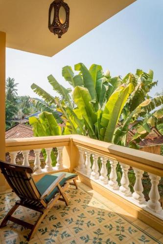 a balcony with a chair and a plant at Le Relais de Chhlong in Kratie