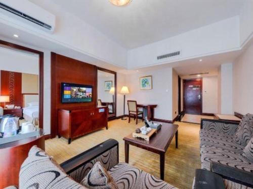 un salon avec un canapé et une table dans l'établissement Borrman Hotel Dongguan Changping Avenue, à Dongguan