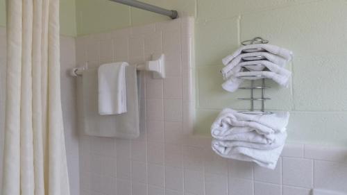 un baño con toallas blancas en un toallero. en Vancouver Motel en Myrtle Beach