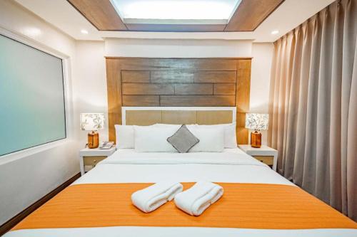 a bedroom with a large bed with two towels at Subic Grand Harbour Hotel Subic Bay in Olongapo