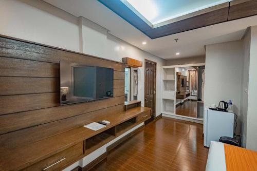 a living room with a flat screen tv on a wall at Subic Grand Harbour Hotel Subic Bay in Olongapo