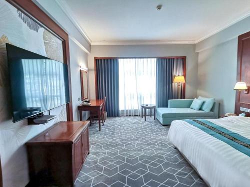 a hotel room with a bed and a couch at Fenggang Gladden Hotel in Tiantangwei