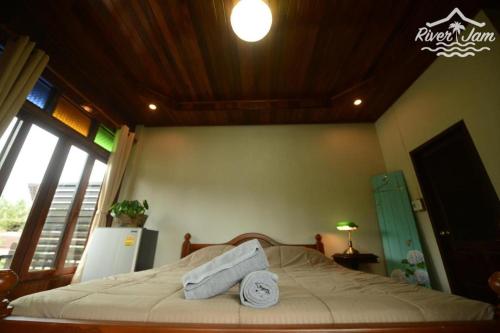 a bedroom with a bed with towels on it at River Jam Amphawa in Amphawa