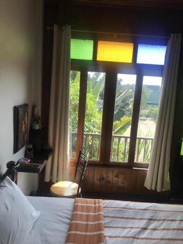 a bedroom with a bed and a window with a view at River Jam Amphawa in Amphawa
